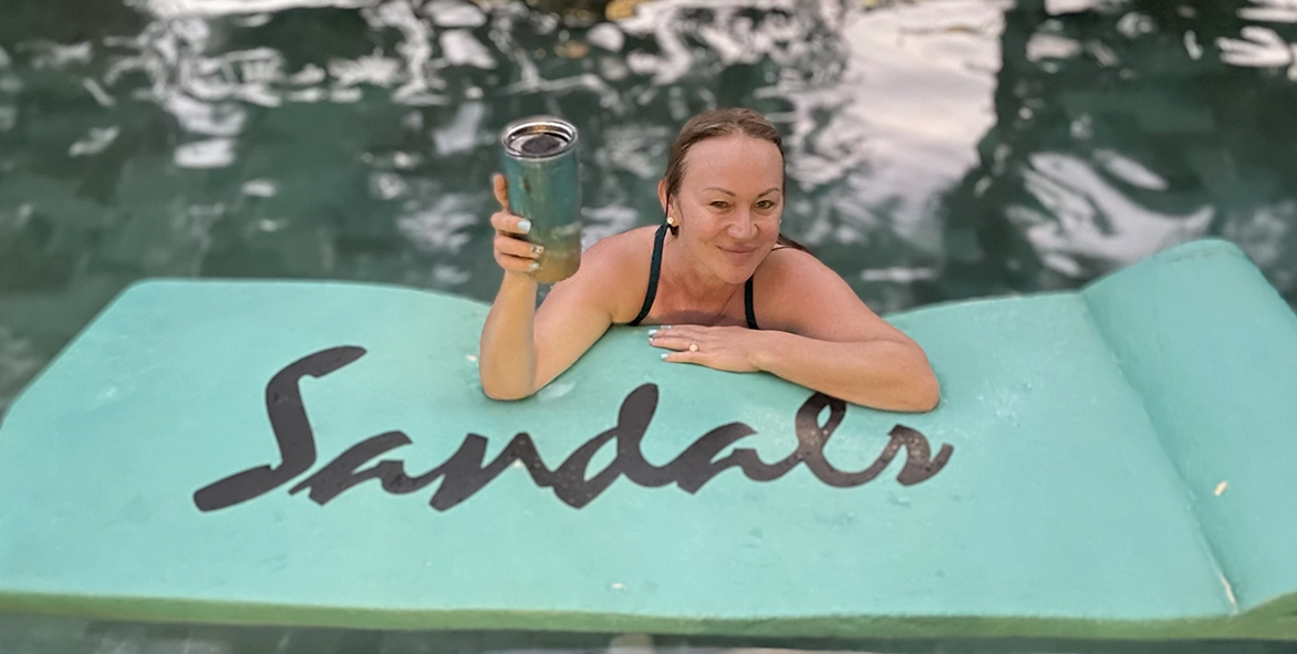 Adriana King, owner of King Luxe Travel, is a certified Sandals and Beaches specialist. Here she is enjoying a cold beverage on a Sandals floating mat.