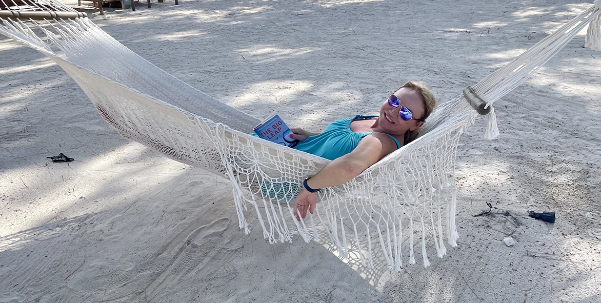 Adriana King, owner of King Luxe Travel, relaxing in a hammock reading a good book.