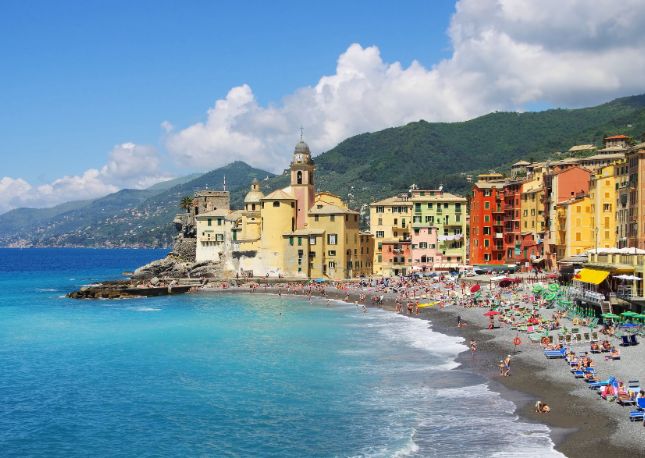 After a charming boat ride from port, arrive in Camogli and admire the vibrant pastel hues of its Ligurian-style seafront homes, painted with intricate “trompe l’oeil” designs that depict blooming flowers and detailed window shutters.