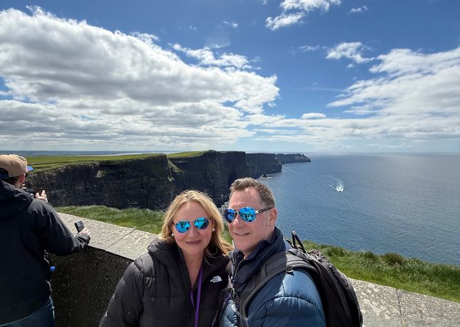 Couple standing in front of the Cliffs of Mother in Ireland.